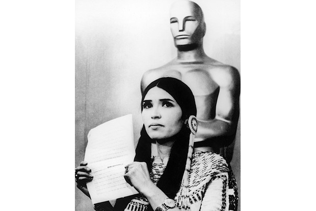 Sacheen Littlefeather holds a written statement from actor Marlon Brando refusing his Best Actor award, on stage at the Academy Awards, 1973. (Hulton Archive/Getty Images)
